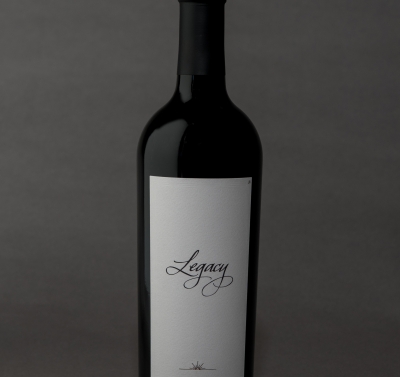 Bottle shot of red wine against a slate gray background