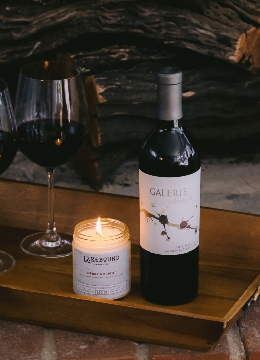 Single bottle of red wine on a tray with a candle