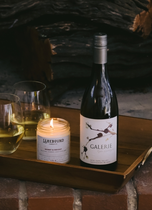 Single bottle of white wine on a tray with a candle