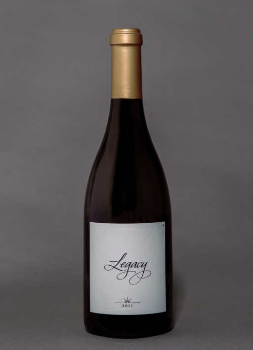 Single bottle of red wine against a gray background