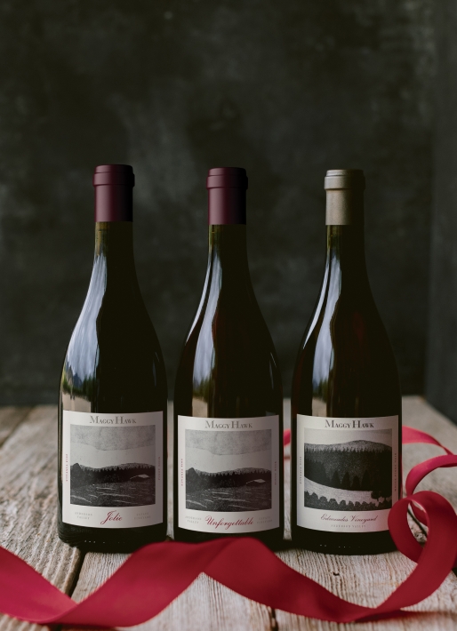 Three bottles of wine against a dark background