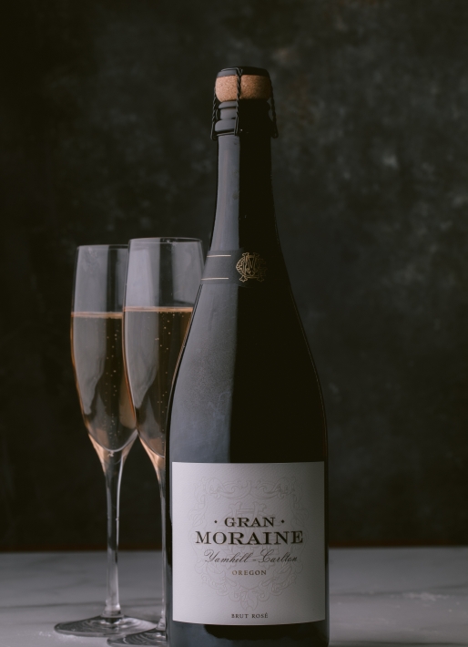 Single bottle of sparkling wine with two glasses on the left side